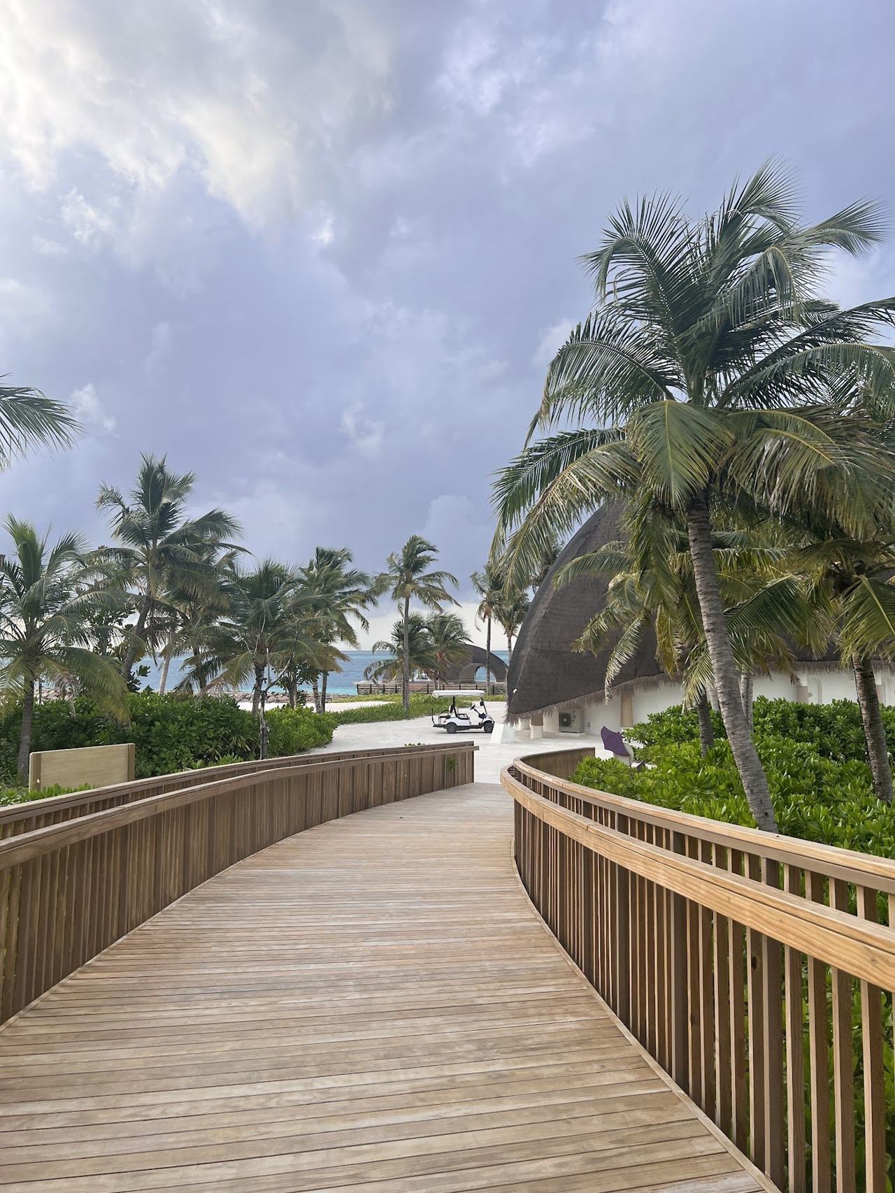 A private stretch of white sand and a calm turquoise lagoon in front of overwater villas in the Maldives