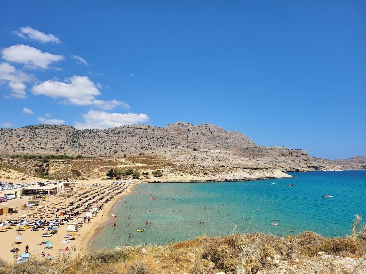 Soft golden sand and shallow turquoise water in the sheltered bay at Agathi beach below Feraklos castle on the east coast of Rhodes