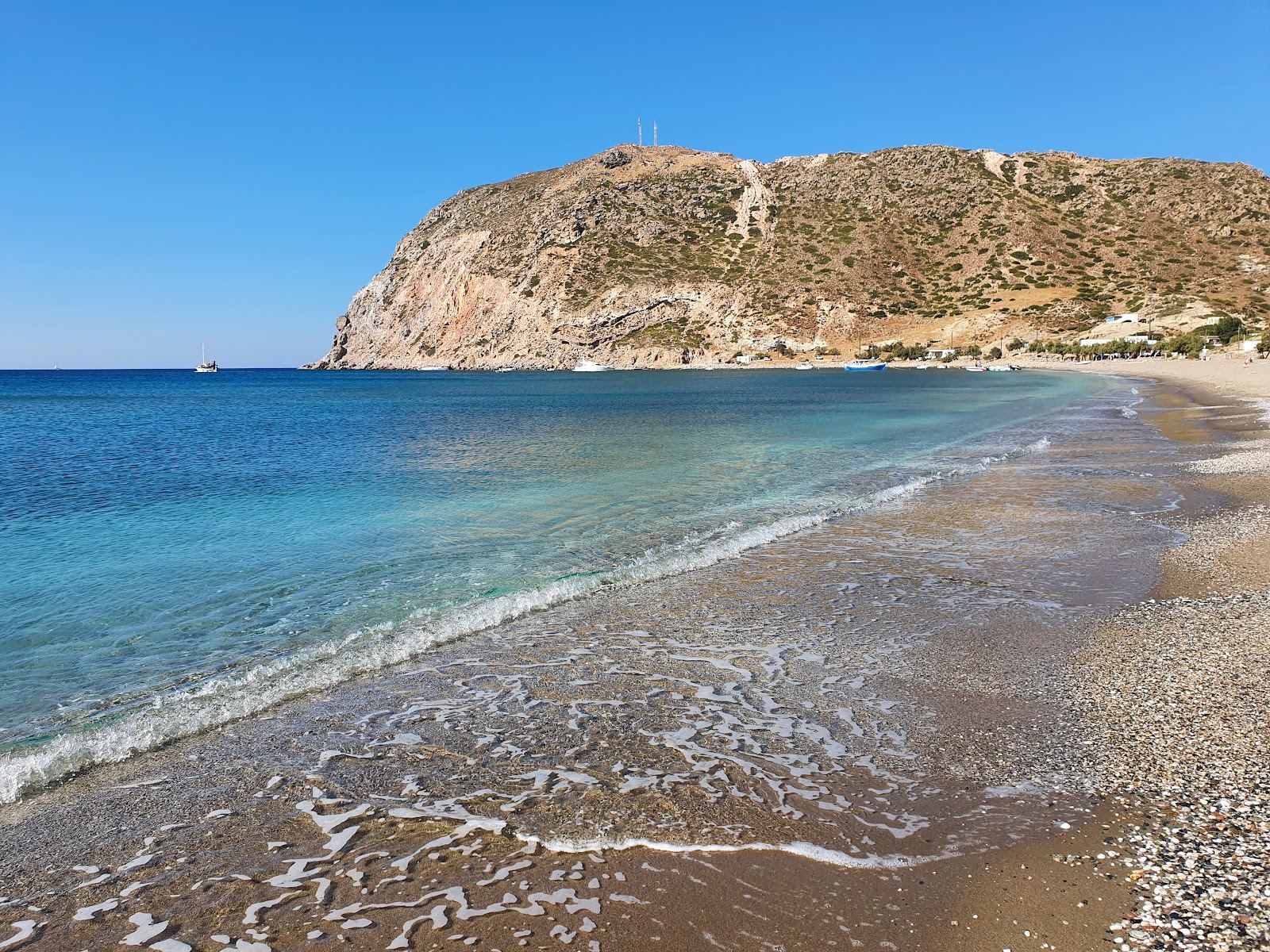 The long sand and pebble shore of Agia Kyriaki beach with clear water on the south coast of Milos