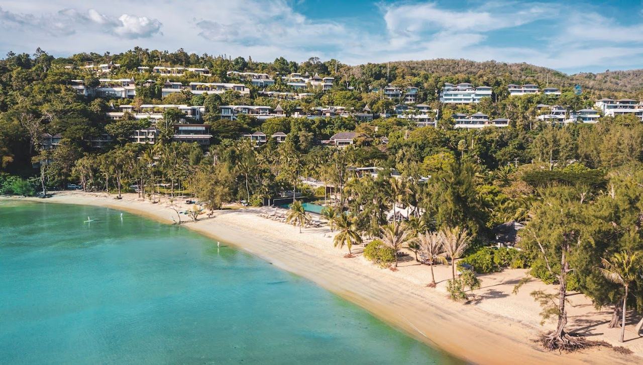 A long calm beach below a polished resort on the west coast of Phuket