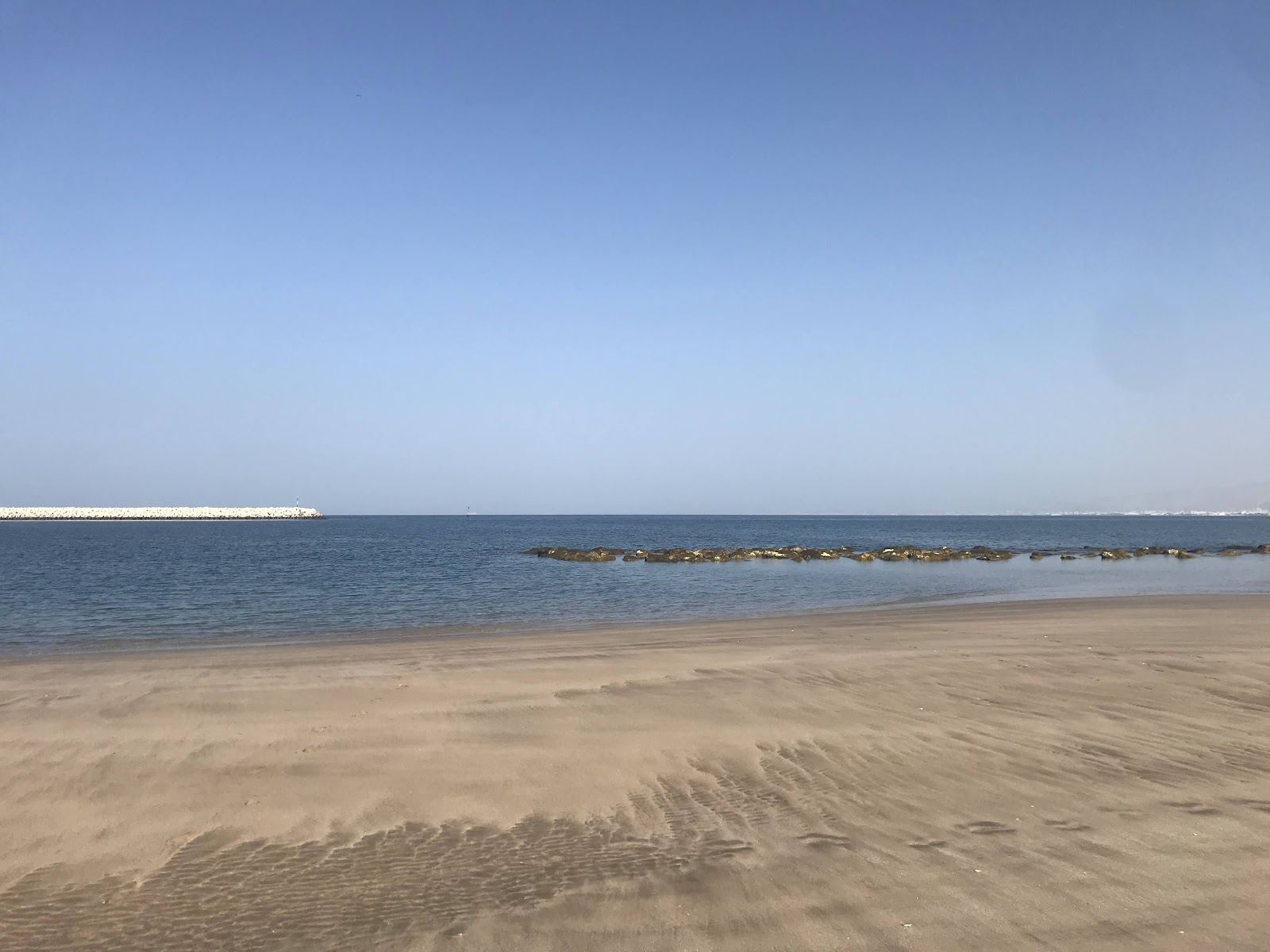 Calm sand and marina promenade at Al Mouj Beach in Muscat