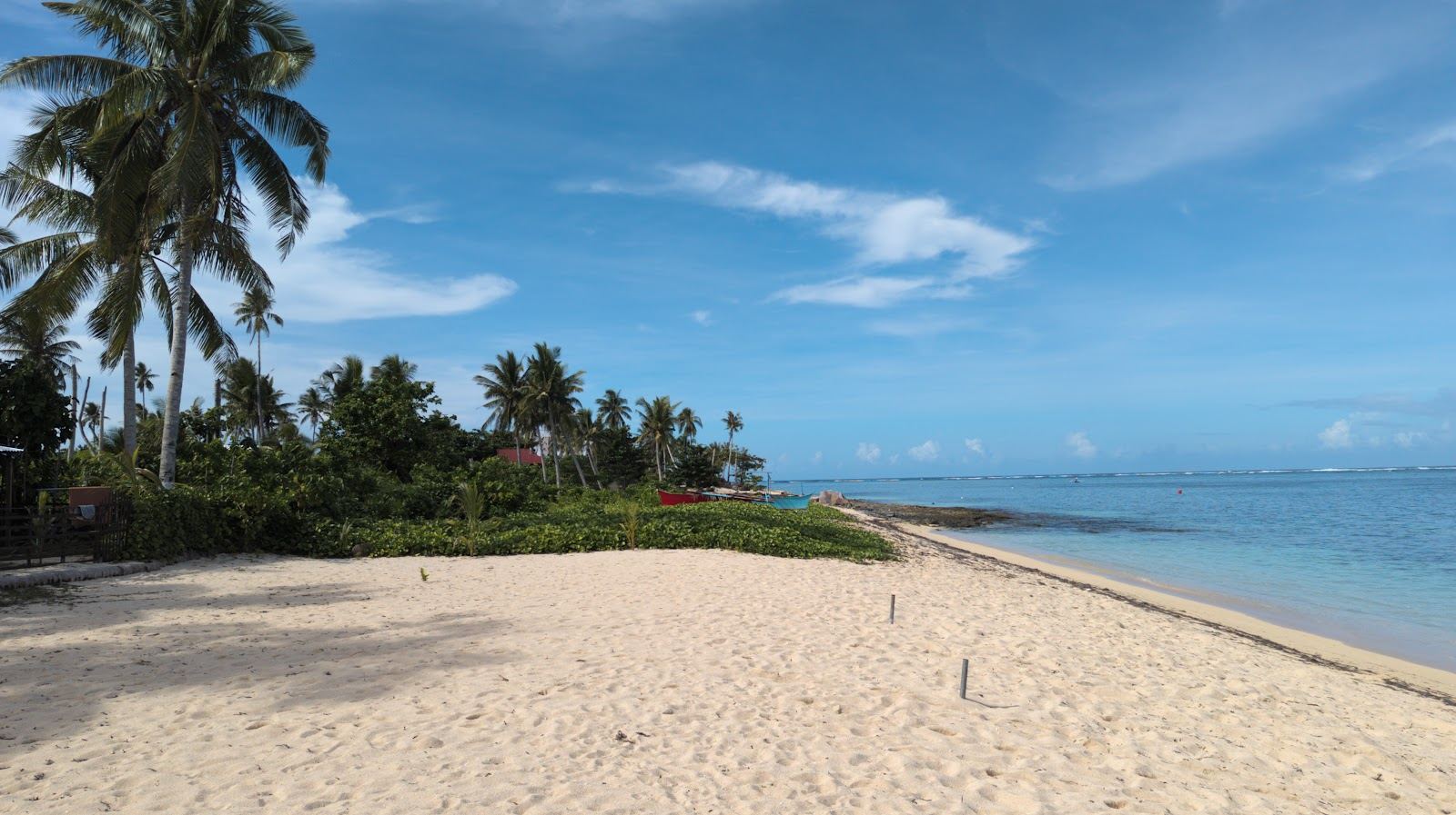 A wide wild beach backed by coconut groves and almost empty under a big sky at Alegria in northern Siargao