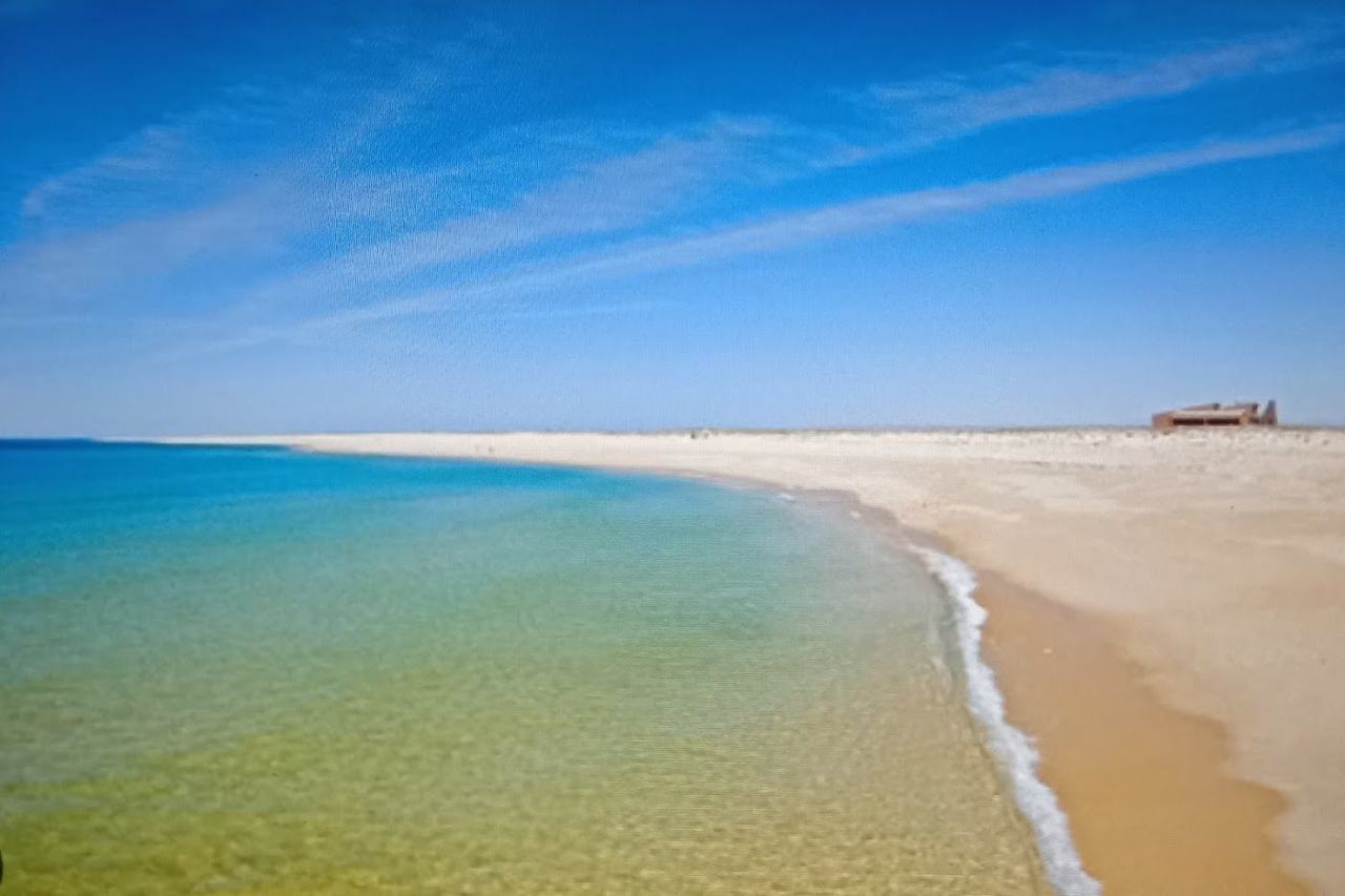 Empty wide sand and dunes under open sky at a remote Algarve island beach