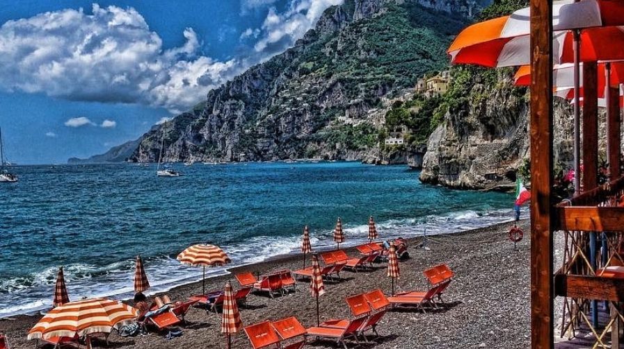 Orange sunbeds at the Arienzo beach club in its pebble cove near Positano on the Amalfi Coast