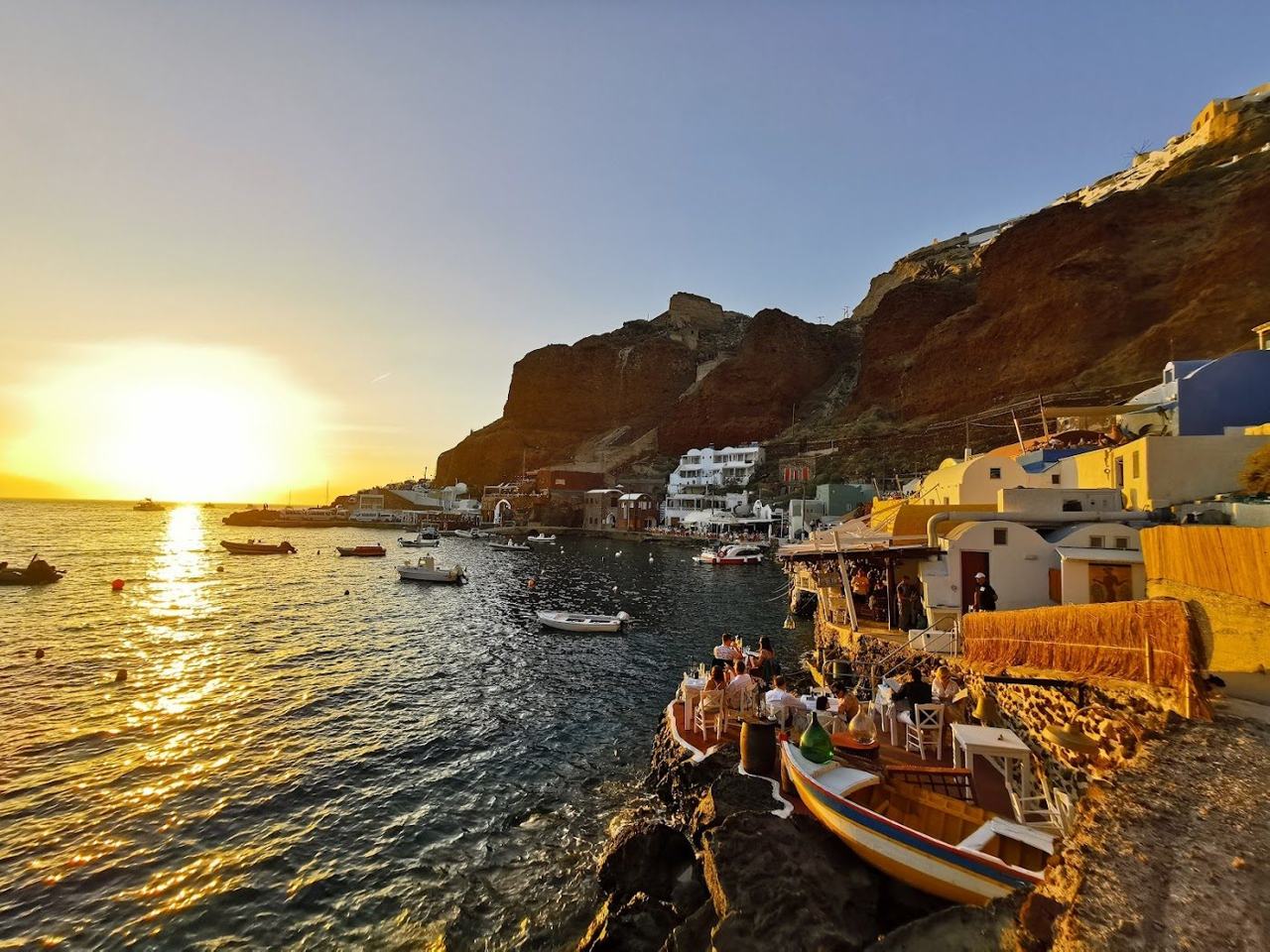 Fishing boats and red cliffs at Ammoudi Bay below Oia in northern Santorini