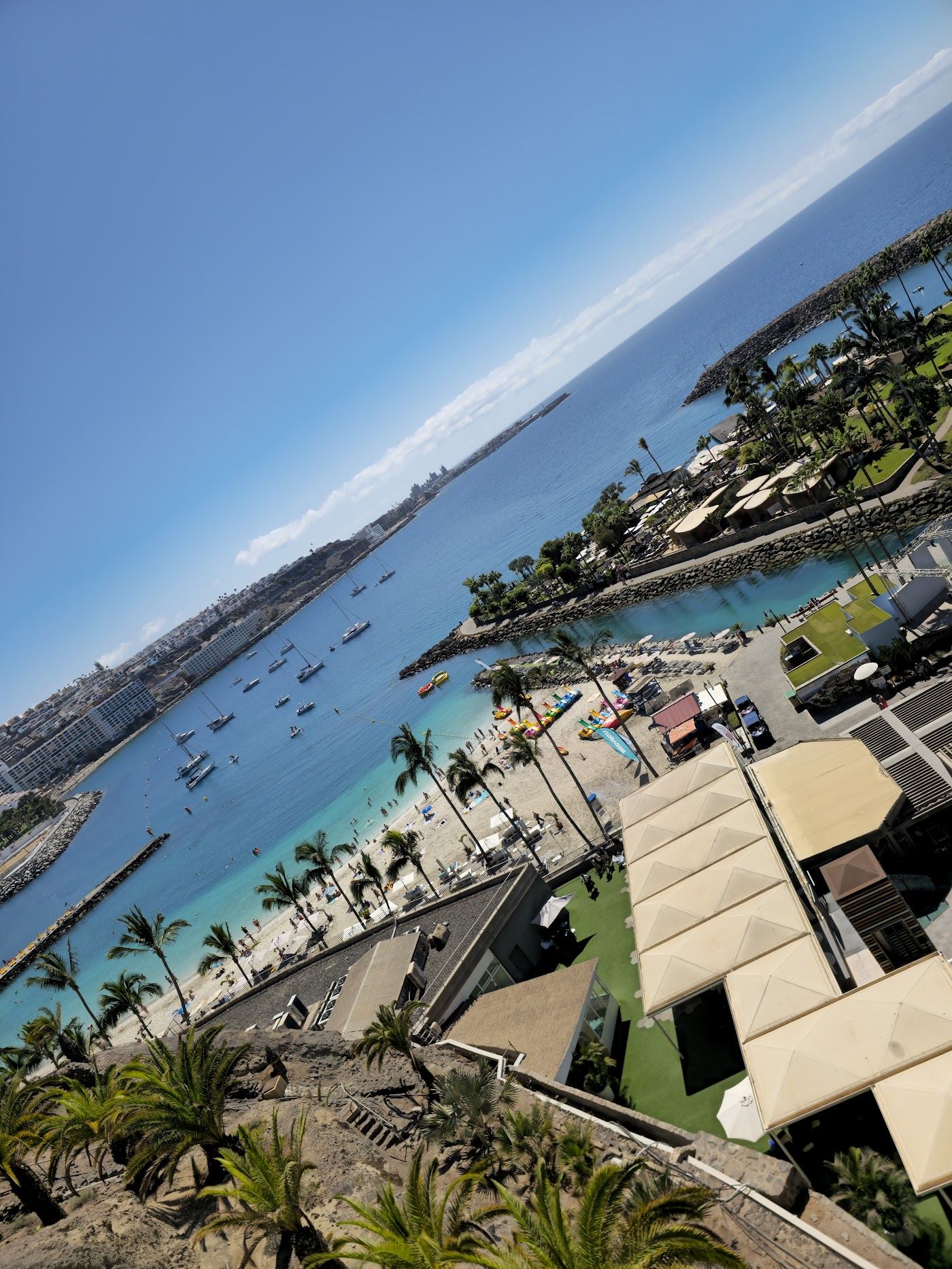 Palm fringed white sand and turquoise water at Anfi del Mar bay in south Gran Canaria