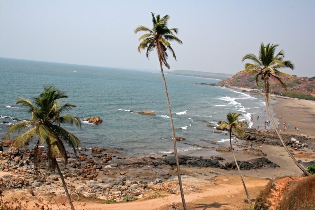 Anjuna Beach red laterite cliffs and rocky sand in North Goa