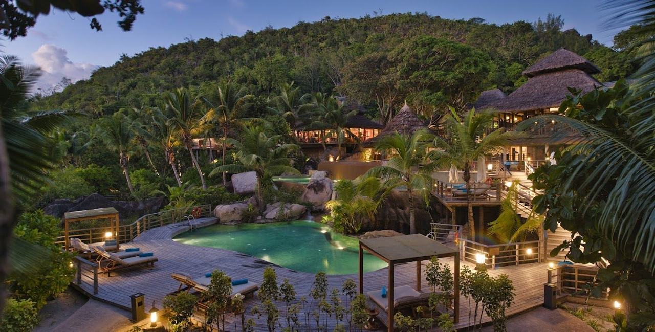 Bright bay and forested hills around Anse Georgette within the Constance Lemuria grounds on Praslin