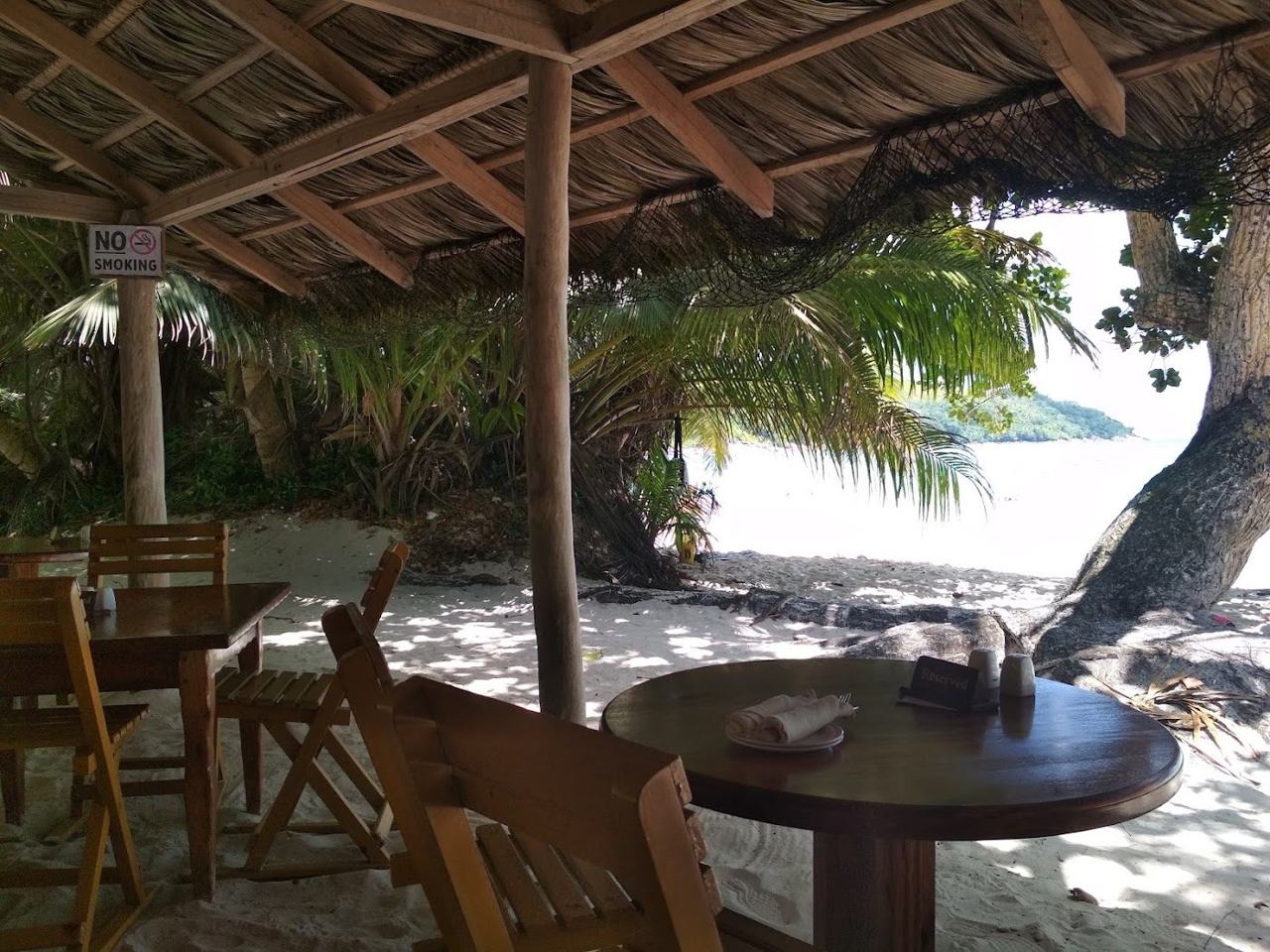 Thatched feet in the sand setting at Bonbon Plume restaurant on Anse Lazio, Praslin