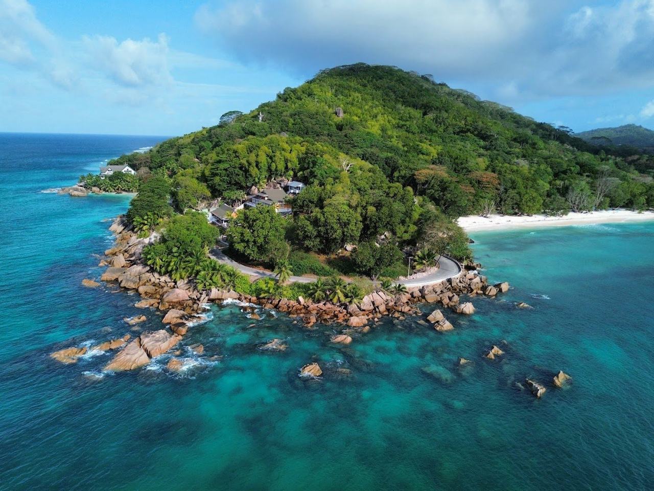 Calm clear water, pale sand and granite at Anse Severe on the north west coast of La Digue in Seychelles