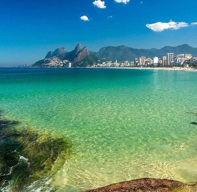 Surfers and sunset crowds on the Arpoador rocks in Rio de Janeiro