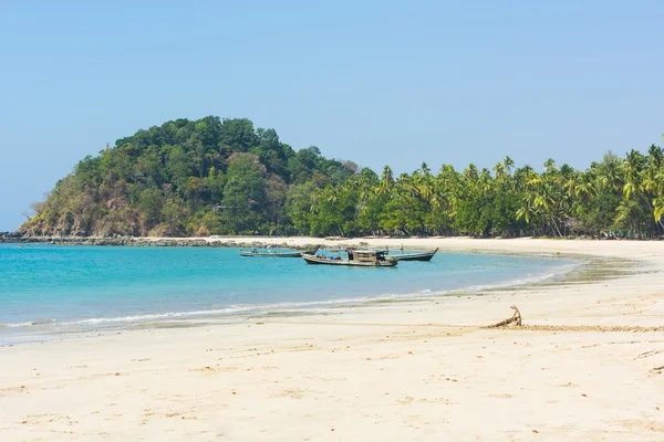 Palms and fishing boats along the quiet sand of Ngapali Beach in Myanmar