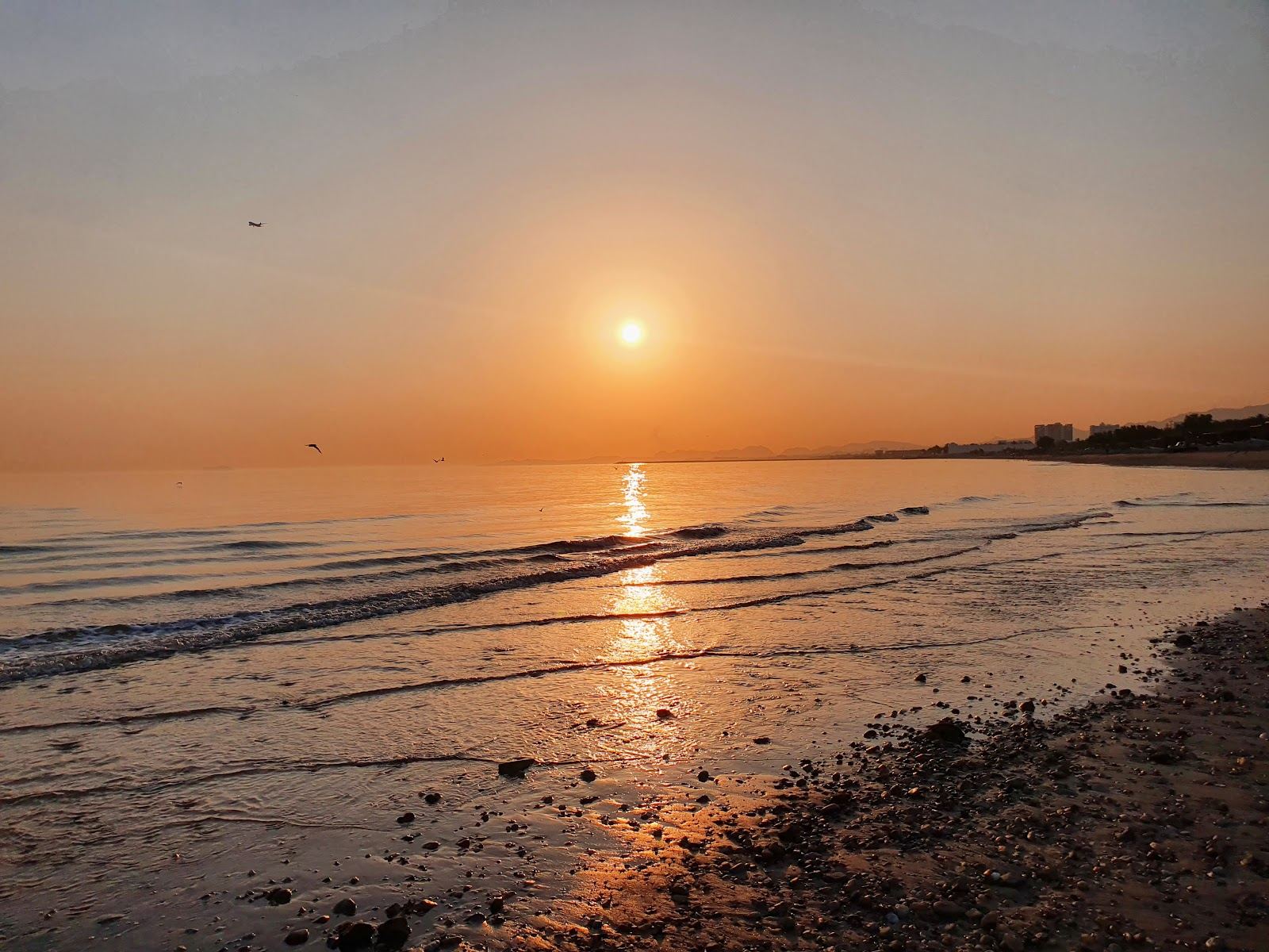 Long open pale sand of Azaiba Beach at dusk in Muscat, Oman