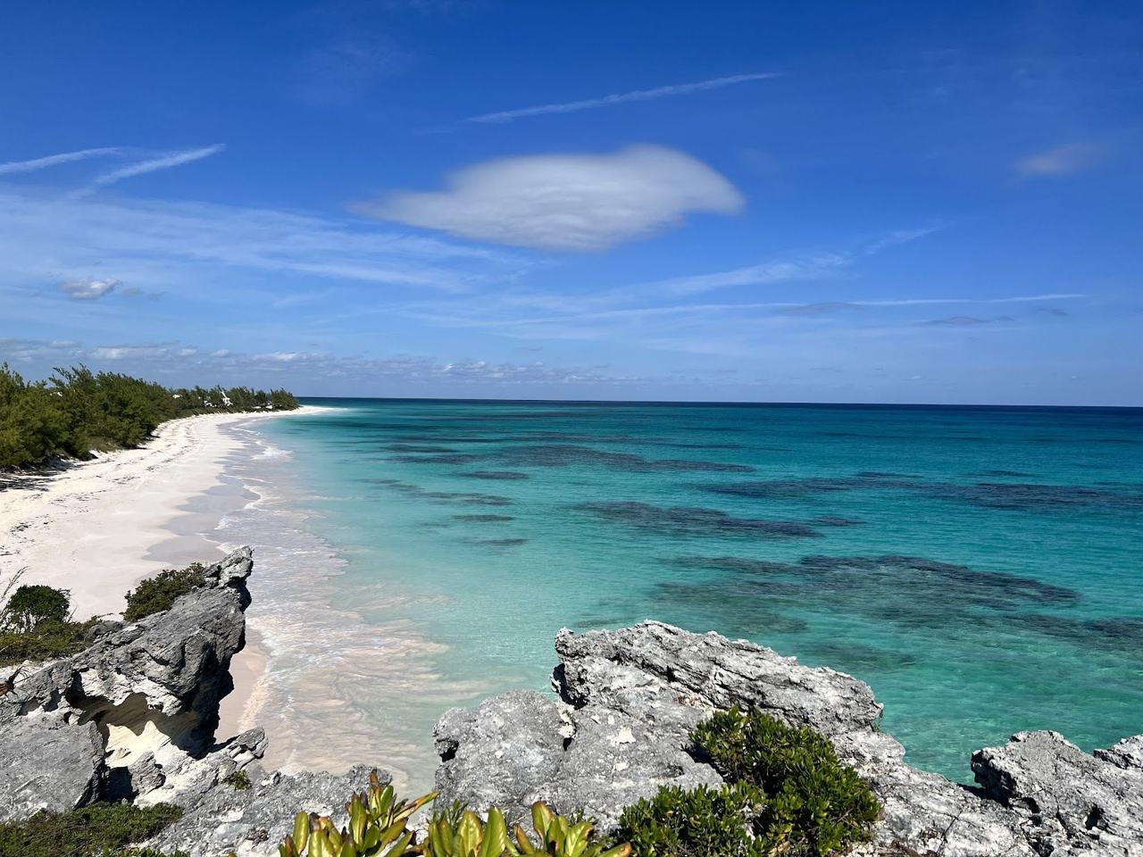 Empty pale sand and clear turquoise water on a remote secluded beach in the Bahamas