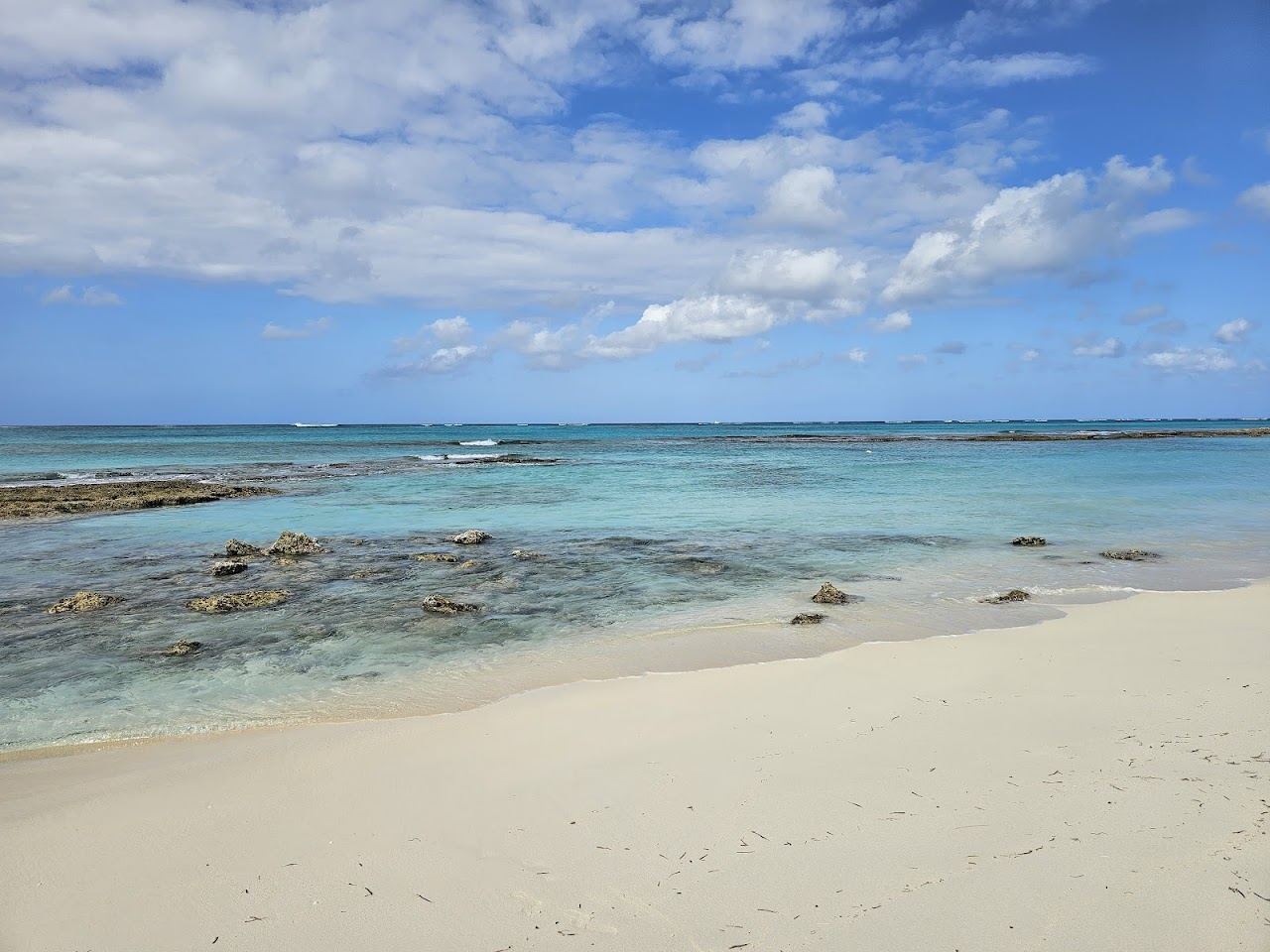 Clear shallow turquoise water over pale sand at Love Beach on New Providence in the Bahamas