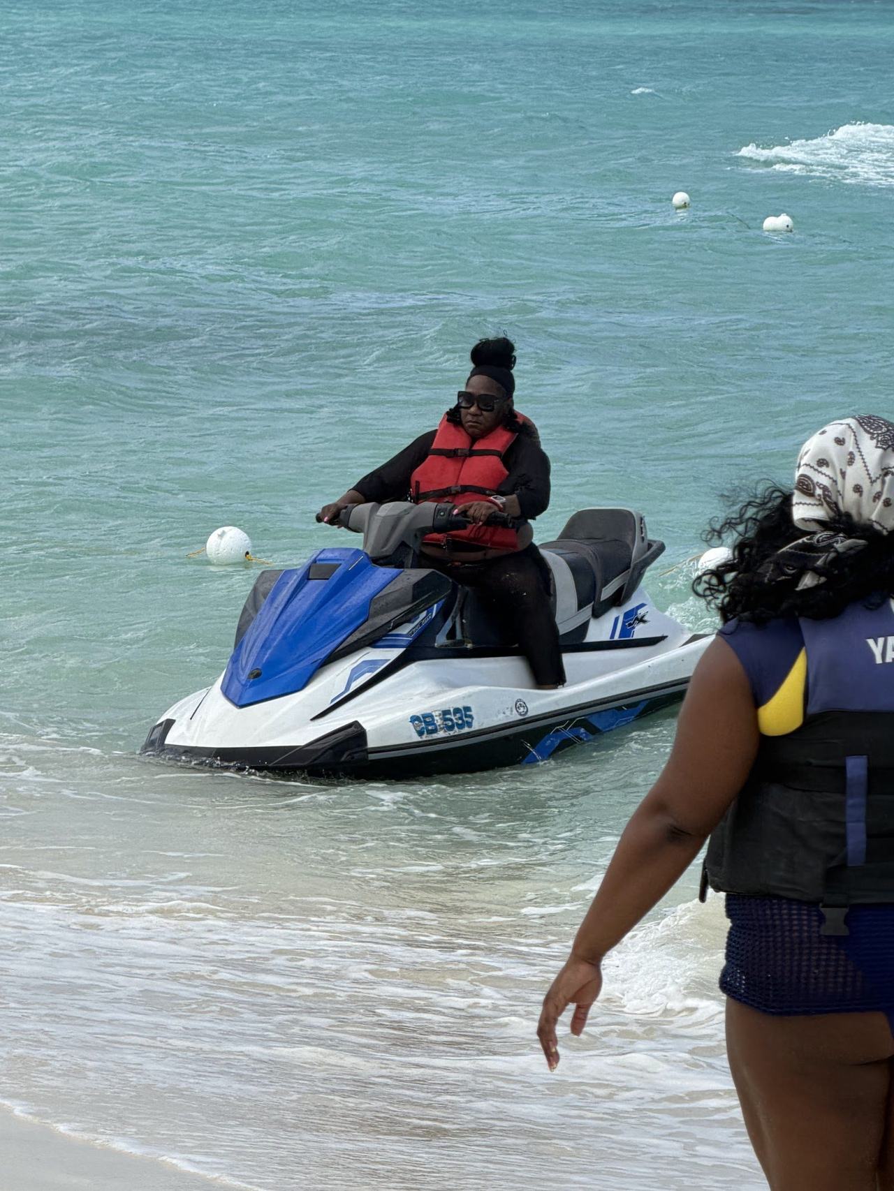 Clear turquoise water and a watersports beach with boats and swimmers in the Bahamas