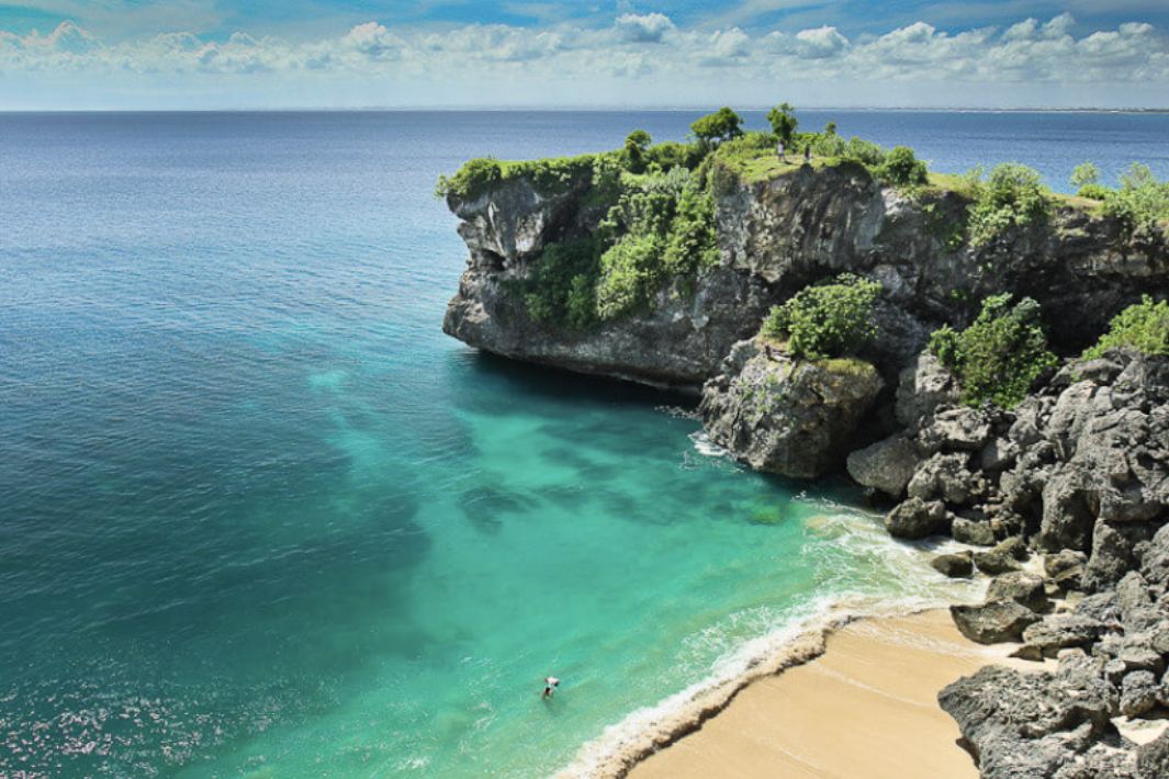 Long wild sweep of sand below cliffs at Balangan Beach on the Bali Bukit