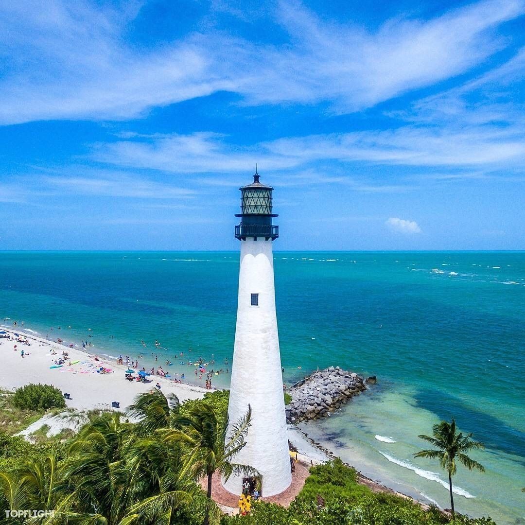 Bill Baggs Cape Florida State Park beach Key Biscayne natural pale sand and calm water with the historic lighthouse and palms