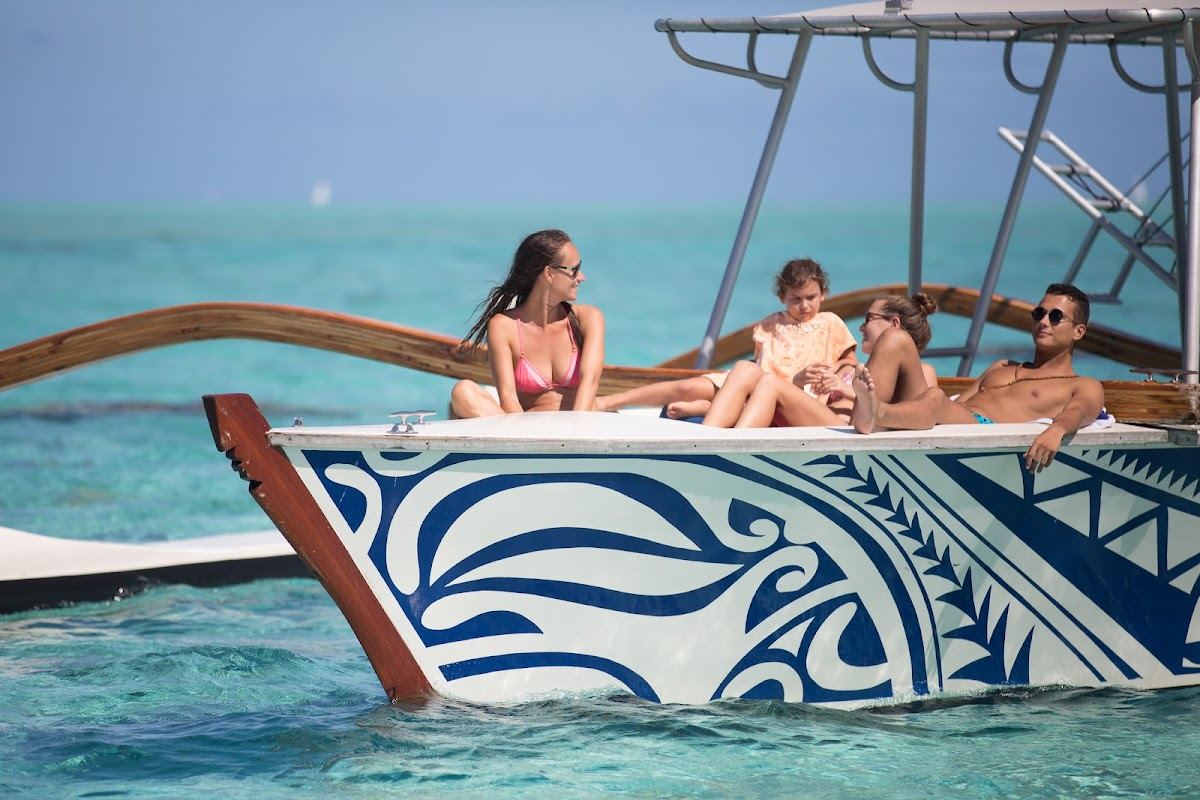 A quiet stretch of pale sand and still turquoise lagoon on an outer motu in Bora Bora