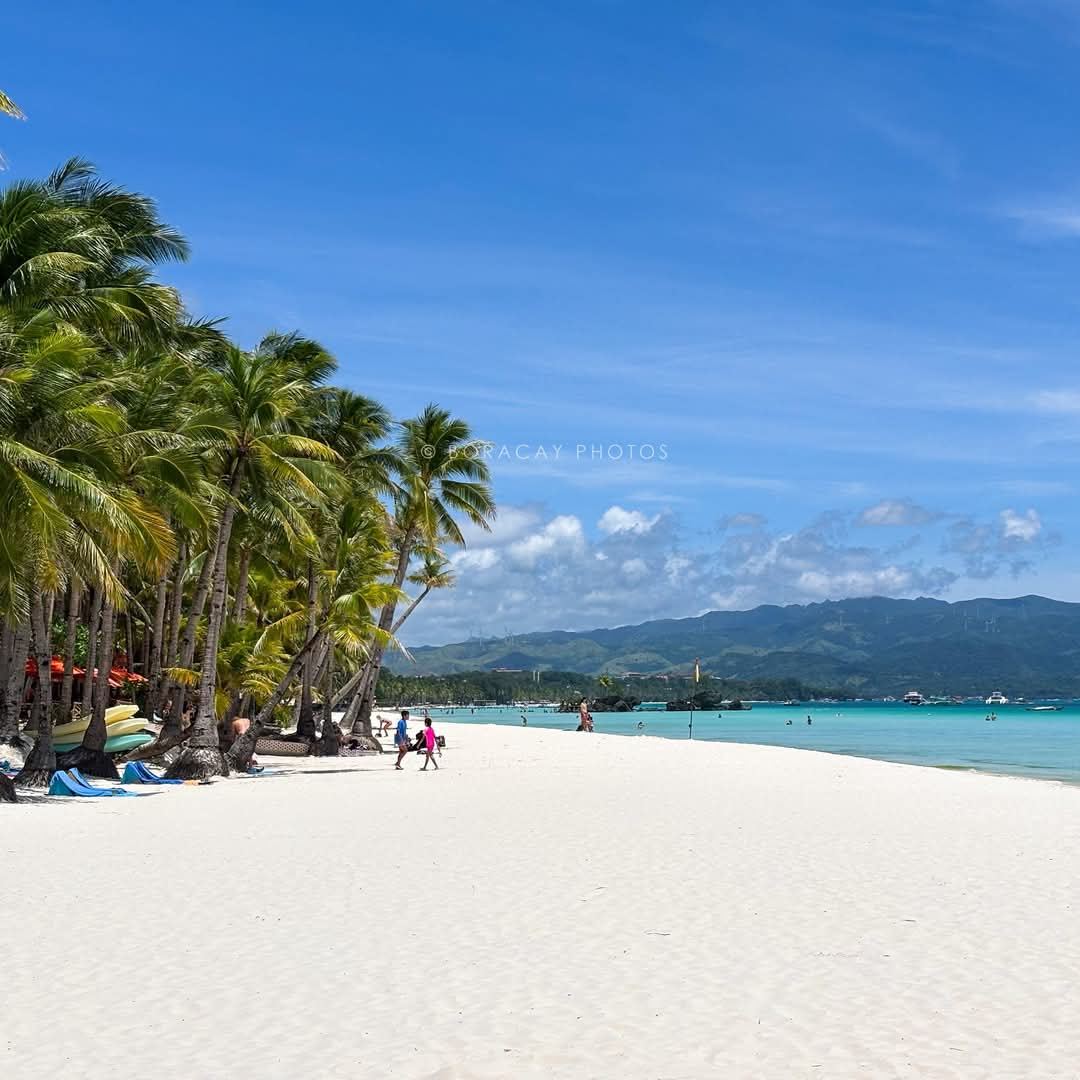 Soft powder sand and calm shallow water at the Station 1 end of White Beach in Boracay