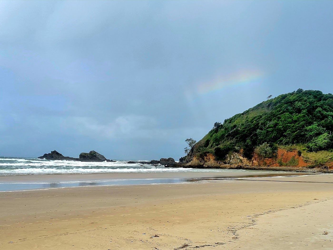 The rainforest backed sand and green headland of Broken Head Beach south of Byron Bay, New South Wales, Australia