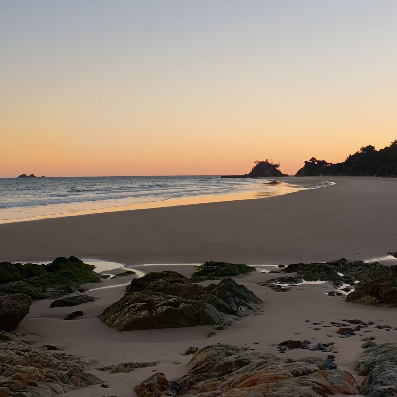 Calm golden sand and gentle water at a sheltered Byron Bay beach suited to families