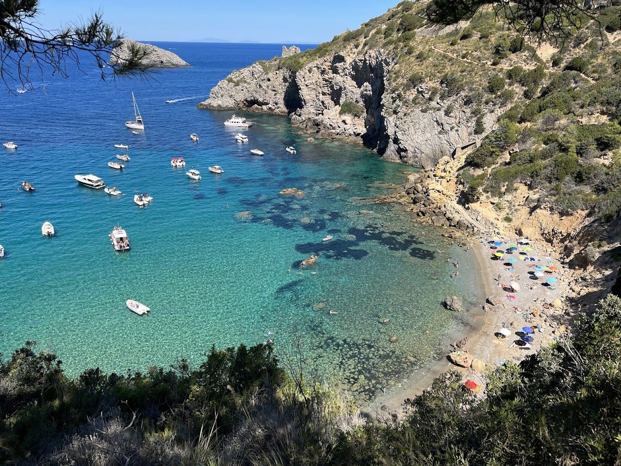 The clear water of Cala del Gesso cove below the Argentario cliffs