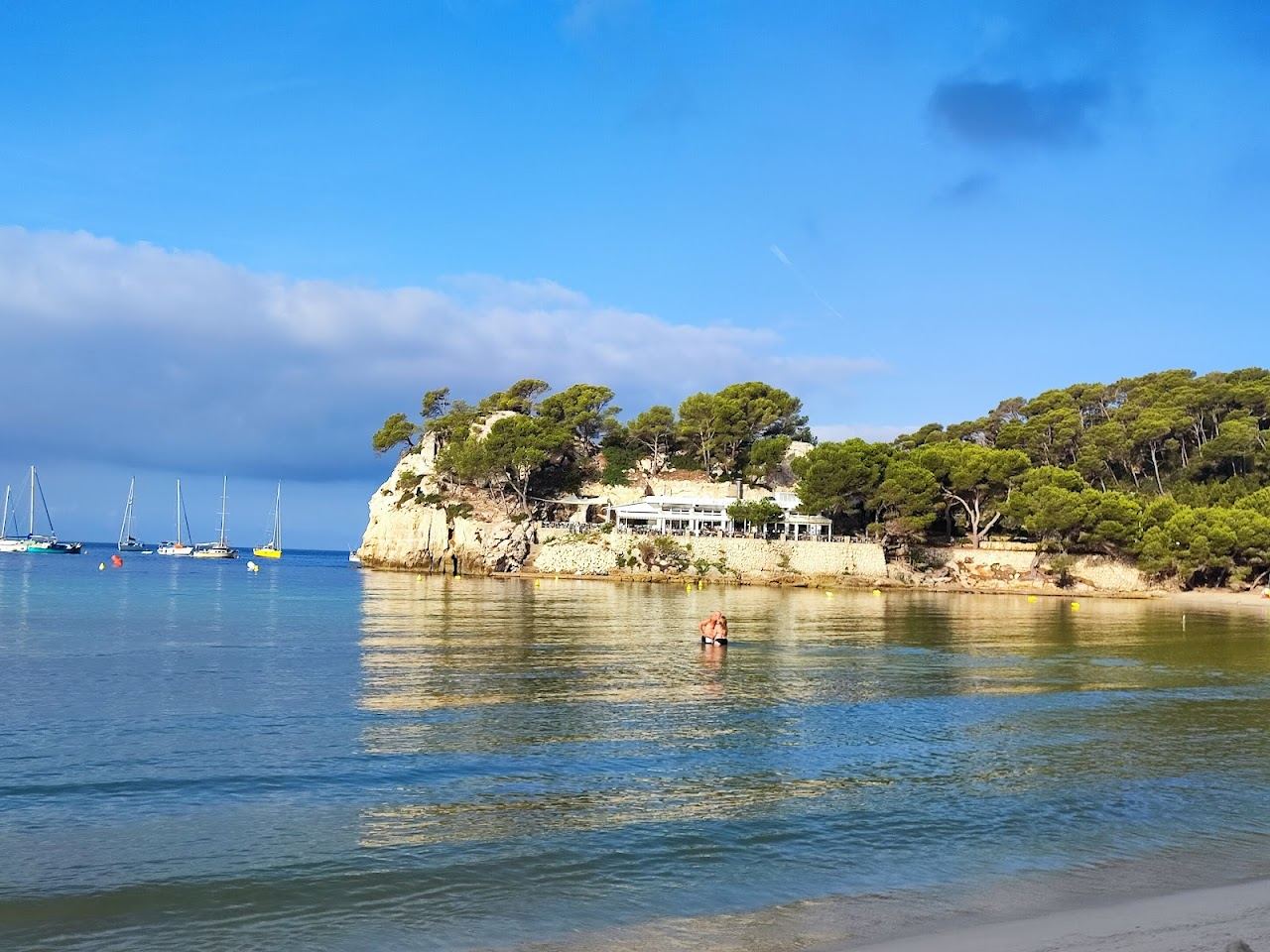 Calm horseshoe bay and pale sand at Cala Galdana in Menorca