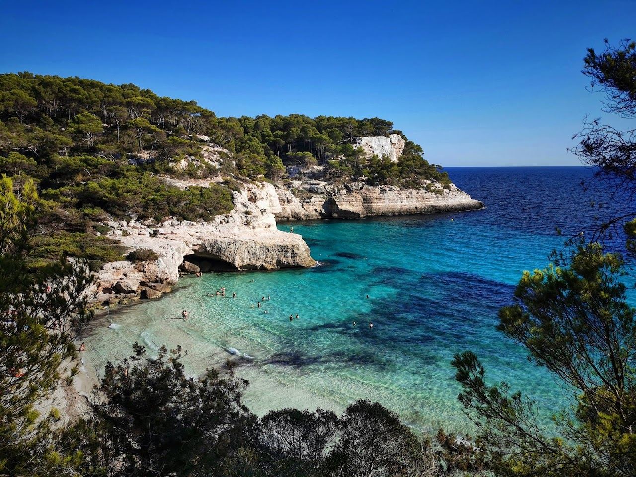 Turquoise water and low cliffs at Cala Mitjana in Menorca