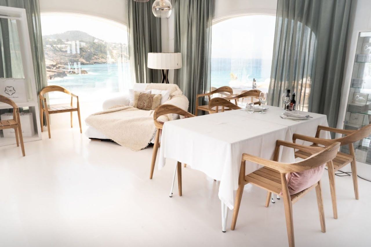 The white walled Cotton Beach Club on the rocks above the golden sand of Cala Tarida in southwest Ibiza