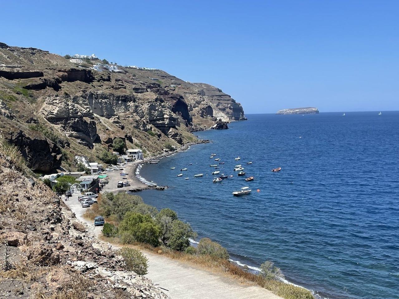 The sheltered black sand cove of Caldera Beach near Akrotiri with a view across to the Santorini volcano