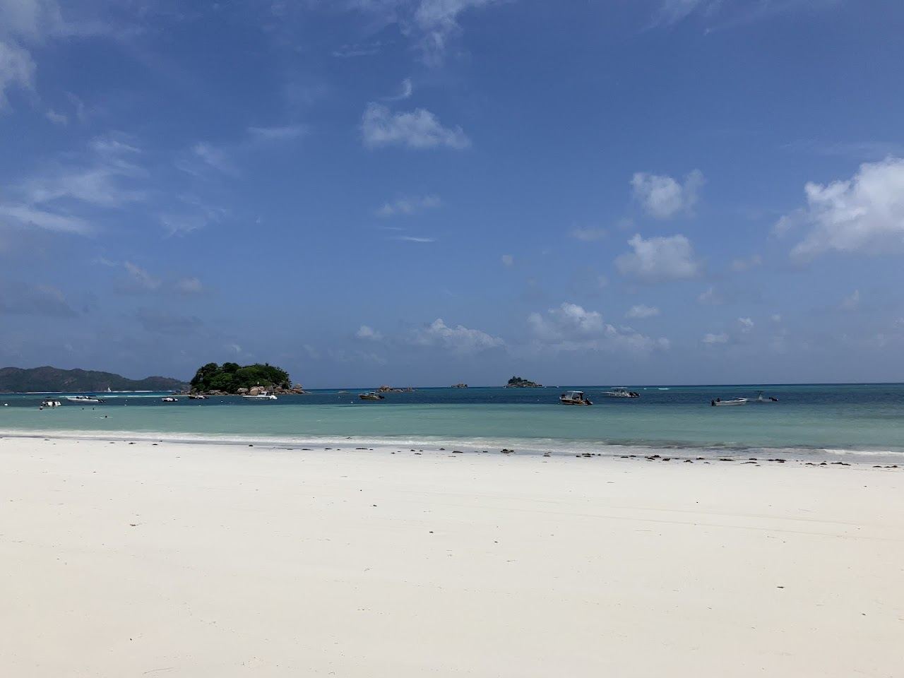 The broad calm bay and soft sand of Anse Volbert on Praslin in the Seychelles