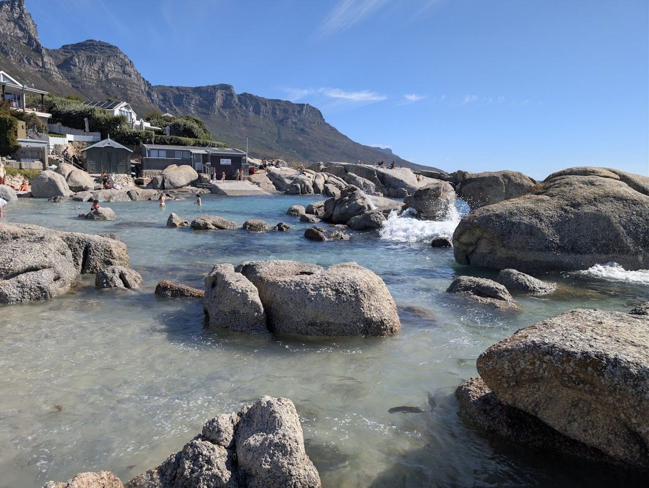 Sheltered sandy cove between granite boulders at Bakoven near Camps Bay in Cape Town