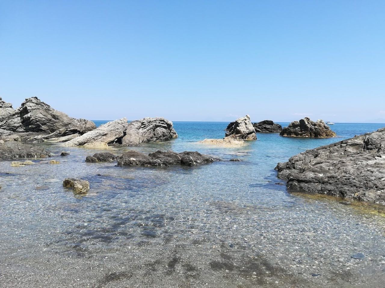 Long sand and shingle beach with headland and clear sea at Capo d'Orlando northern Sicily
