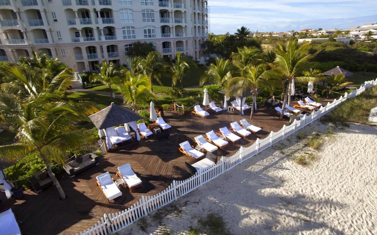 Loungers and a poolside bar steps from the white sand at Seven Stars on Grace Bay