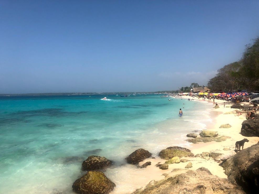 White sand and turquoise water with beach clubs and crowds at Playa Blanca on Baru near Cartagena