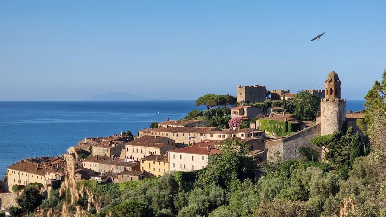 The canal harbour and old town of Castiglione della Pescaia behind the beach