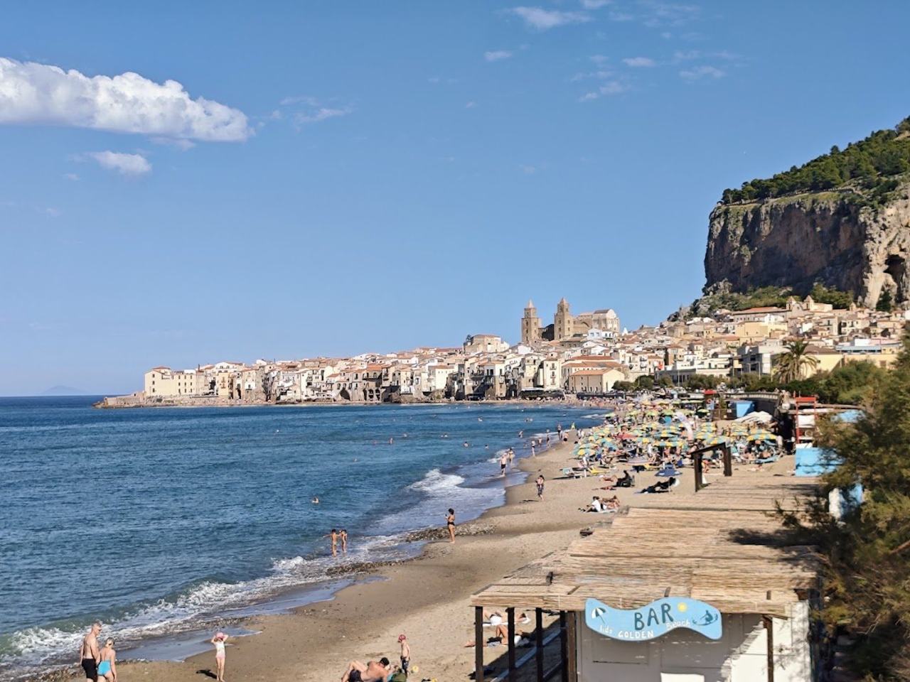 Cefalu sandy beach below the medieval old town and La Rocca on the north coast of Sicily