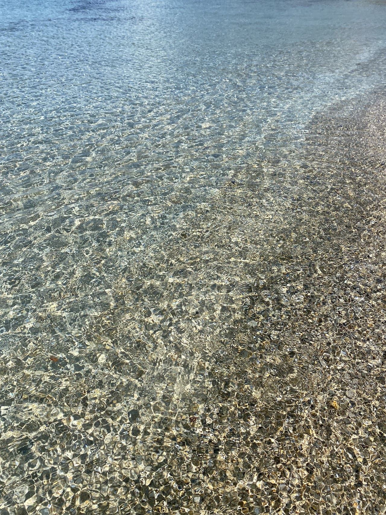 The bright white sand and breezy shallow water of Pirlanta Beach at the western tip of the Cesme peninsula in Turkey