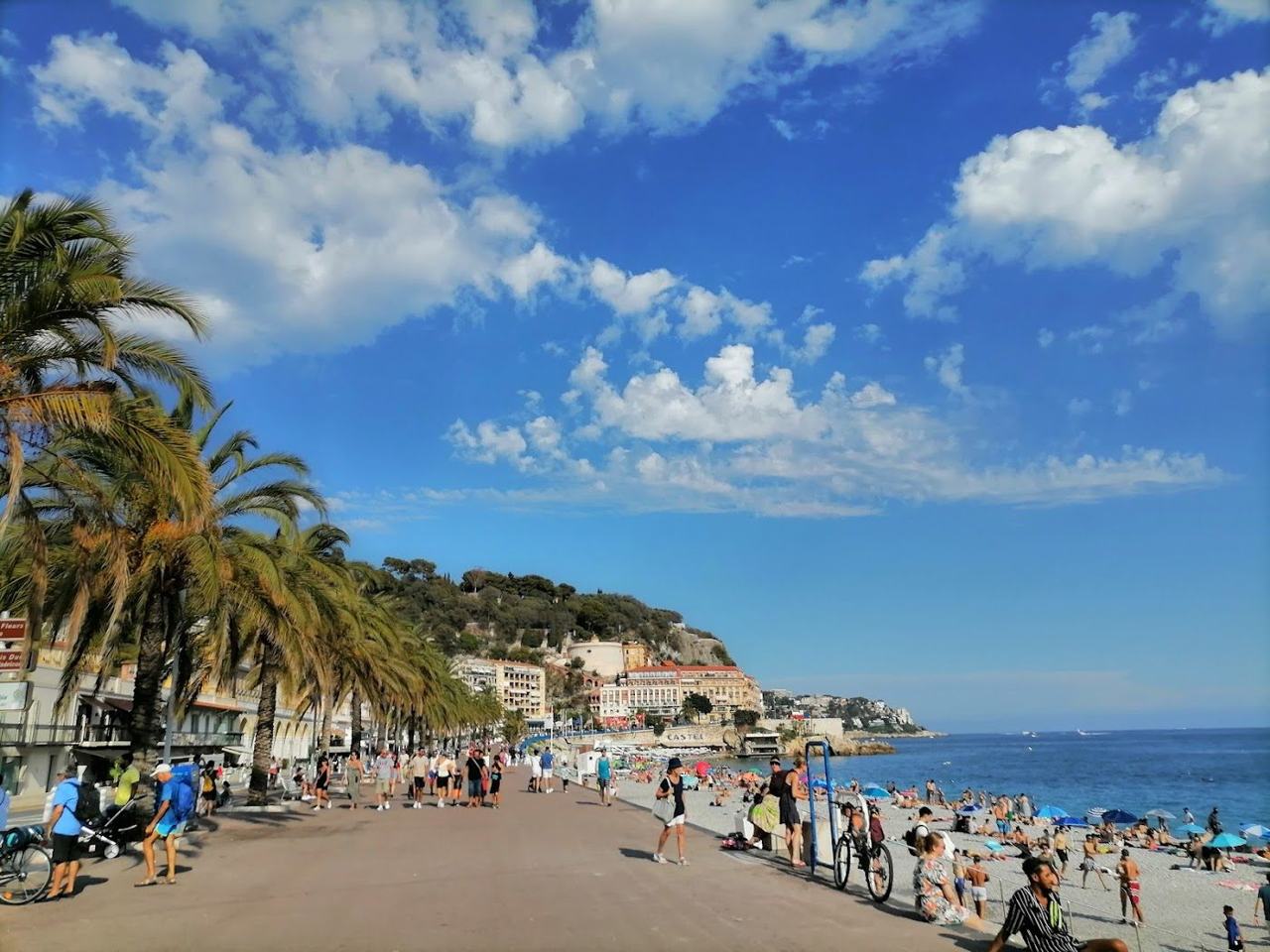 The pebble beach of Nice along the Promenade des Anglais with the city curving behind