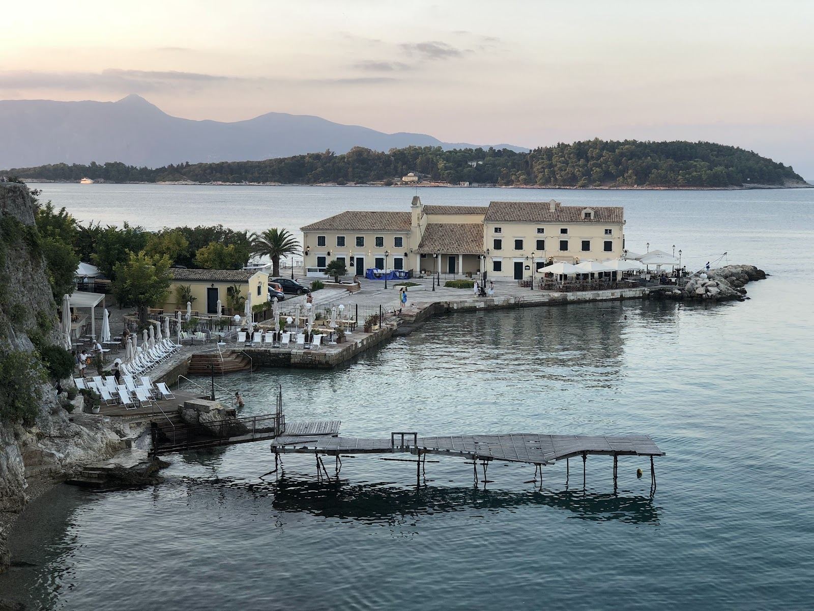Clear Ionian water and a green cliffed Corfu coastline under summer light