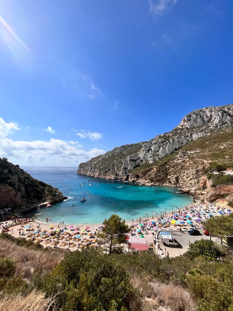 Turquoise water and pine covered cliffs at Cala Granadella near Javea on the Costa Blanca