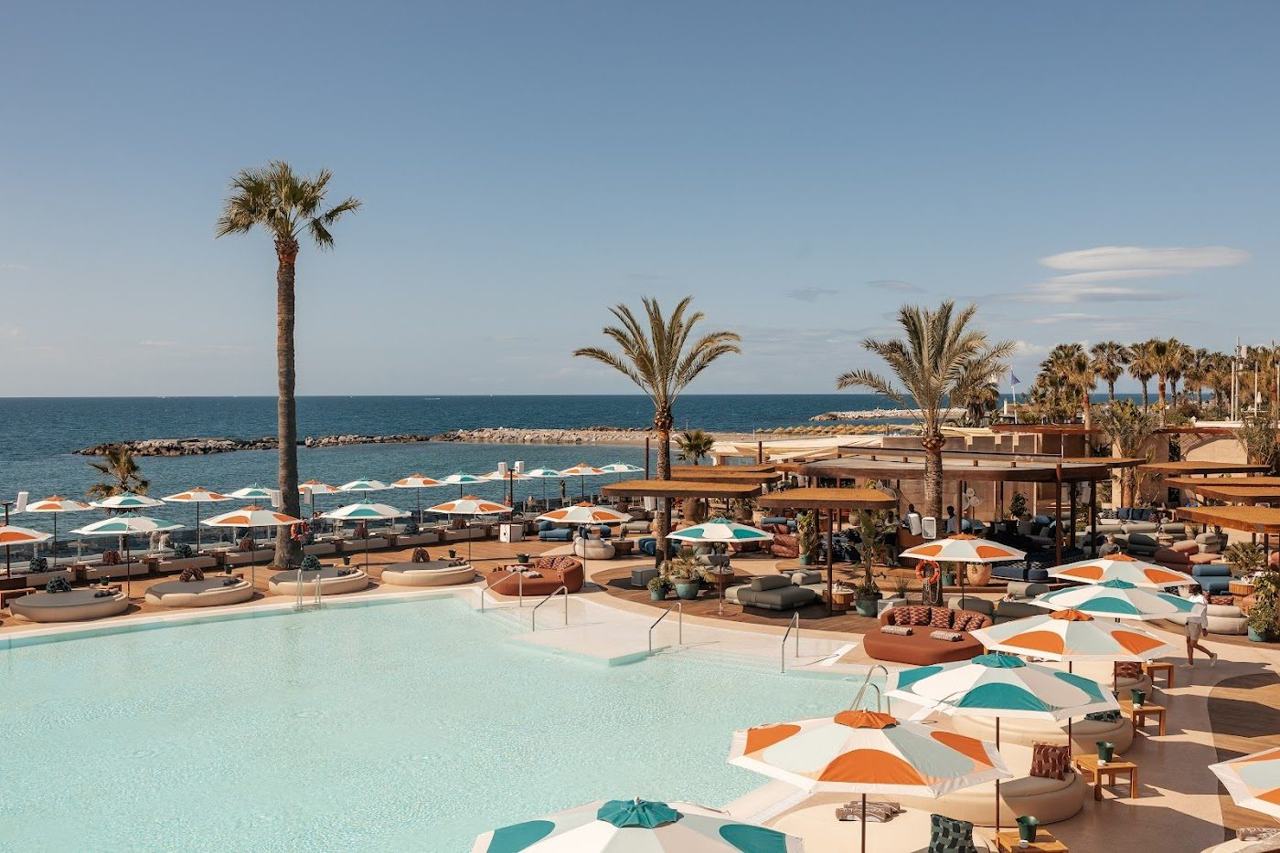 Pool, daybeds and sea views at a glamorous beach club in Puerto Banus on the Costa del Sol