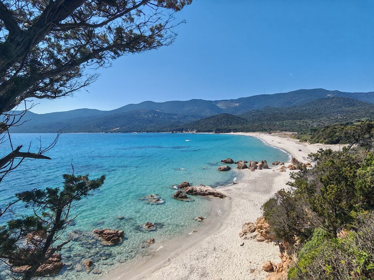 Open sandy bay of Cupabia in the Gulf of Valinco, Corsica, with green hills around it
