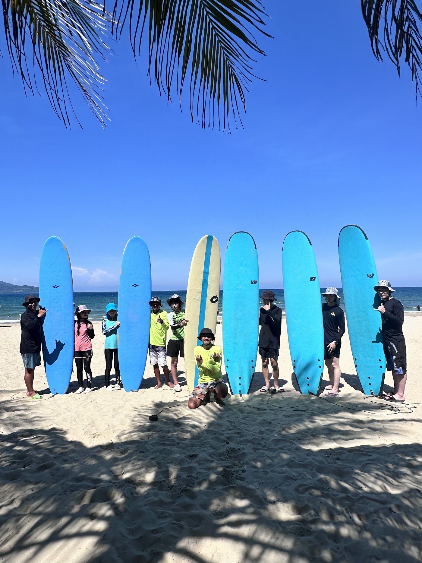 Surf rolling in along My Khe Beach in Da Nang, Vietnam, with boards on the sand