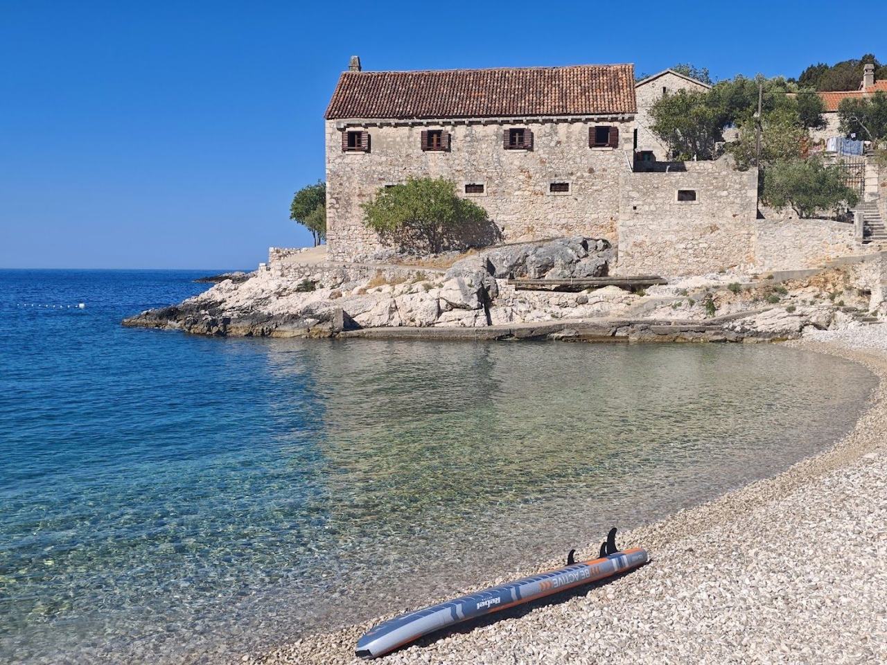 Turquoise cove with a single old stone house at Dubovica south of Hvar town