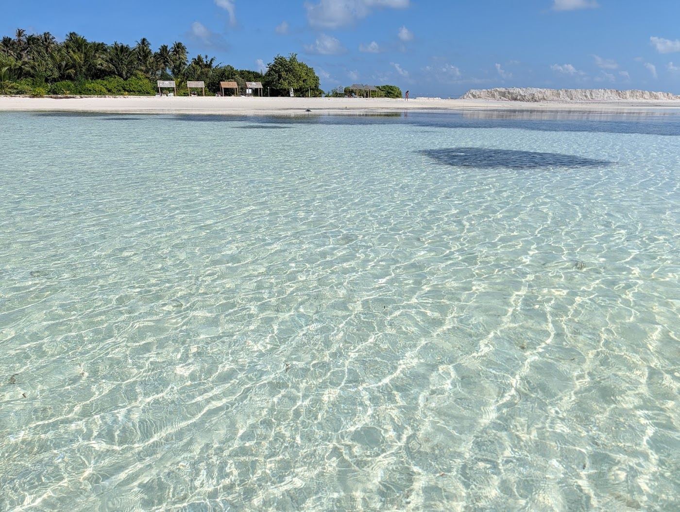 Soft white sand and shallow turquoise water on a bikini beach at Dhiffushi in the Maldives