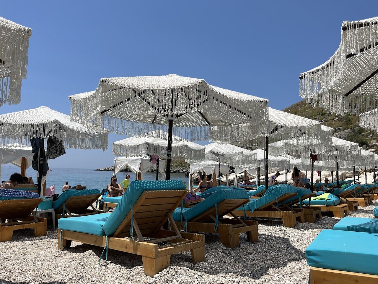 Sunbeds of Mumbas Beach Club, often listed under Drymades but sited on Llamani cove near Himara