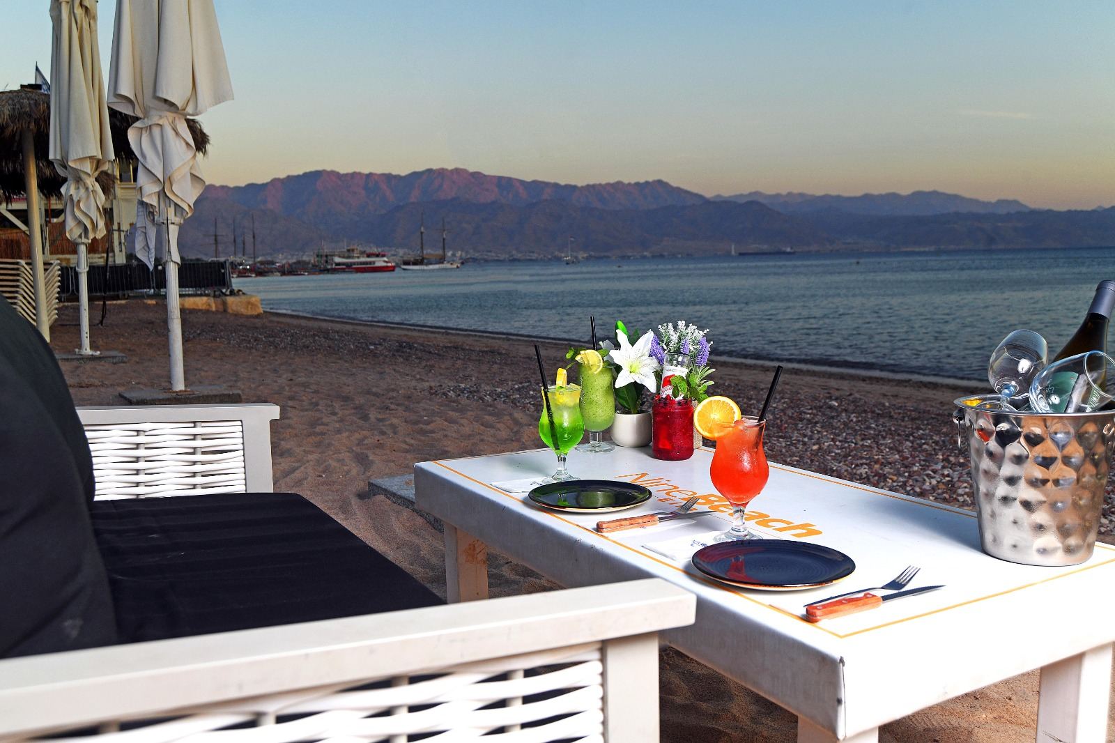 Sun loungers and the calm Red Sea at dusk on a beach in Eilat