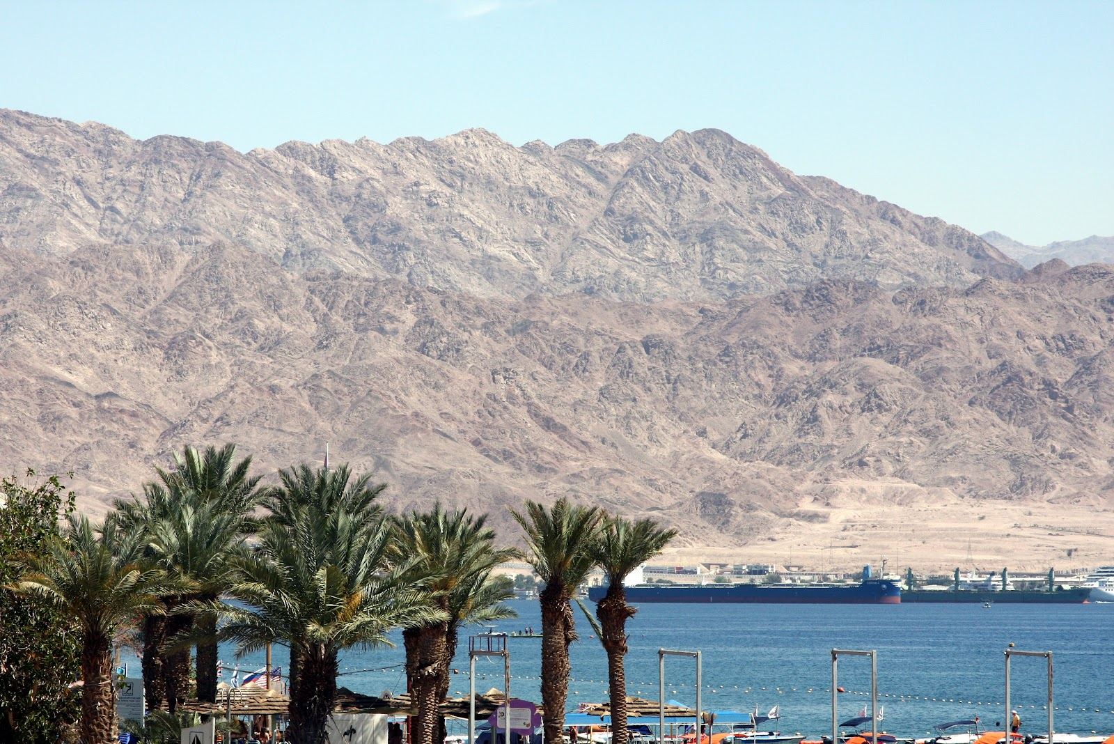 The promenade and beach at North Beach in Eilat with the desert mountains behind